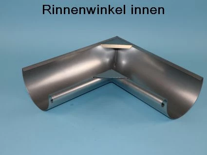 Eckstück für Dachrinnen, aus Metall gefertigt, mit einer Innenwinkel-Form. Es zeigt eine glatte Oberfläche und Löcher zur Befestigung. Der Hintergrund ist einfarbig blau. Oben steht der Text: -Rinnenwinkel innen-.
